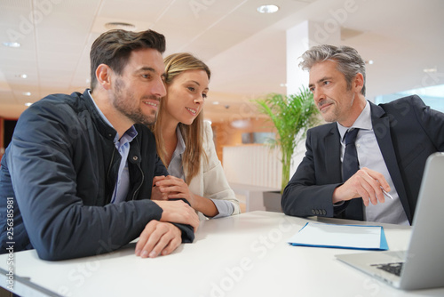 Couple signing contract with real estate agent
