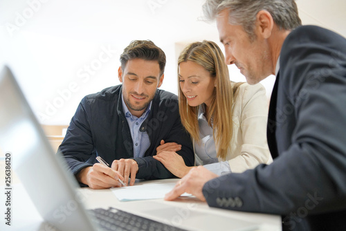 Couple signing contract with real estate agent