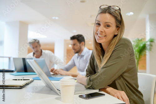 Female startup team member smiling at camera in office photo