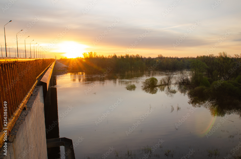 Fototapeta premium wschodzące słońce nad rzeką podczas powodzi