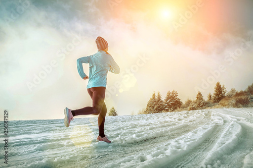 Running woman. Runner on the snow in winter sunny day. Female fi