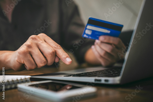 Businessman holding credit card and typing on laptop for online shopping and payment makes a purchase on the Internet, Online payment, Business financial and technology photo