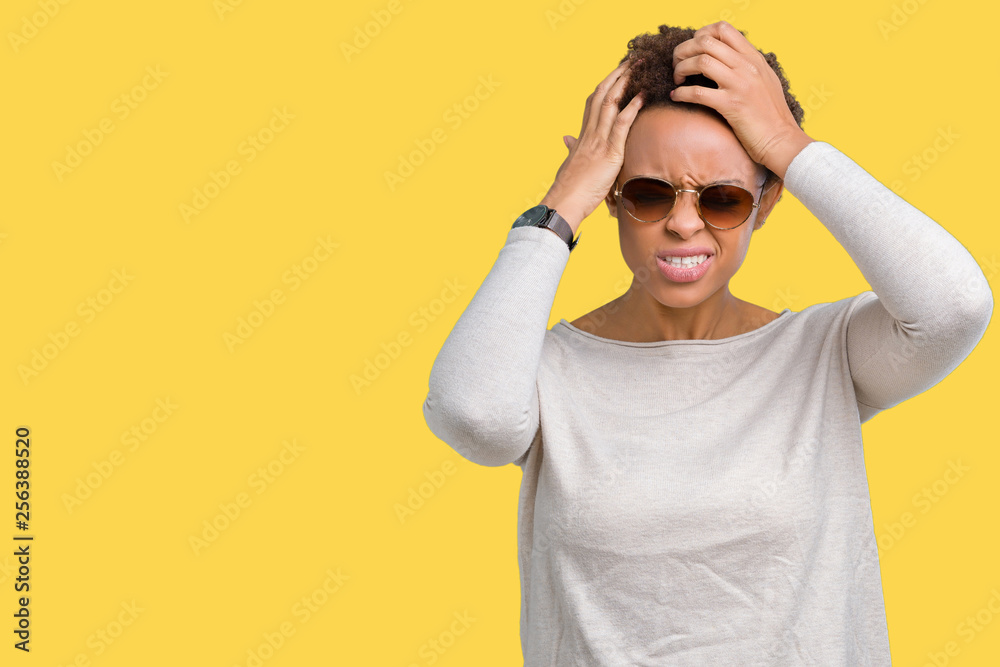 Beautiful young african american woman wearing sunglasses over isolated background suffering from headache desperate and stressed because pain and migraine. Hands on head. Beautiful young african american woman wearing sunglasses over isolated background suffering from headache desperate and stressed because pain and migraine. Hands on head.
