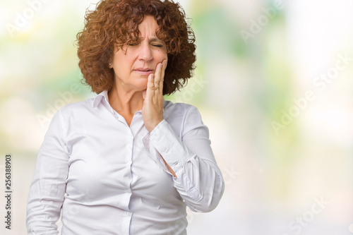 Beautiful middle ager senior businees woman over isolated background touching mouth with hand with painful expression because of toothache or dental illness on teeth. Dentist concept.