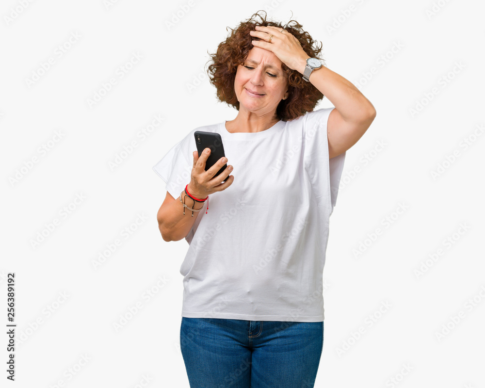 Middle ager senior woman using and texting with smartphone over isolated background stressed with hand on head, shocked with shame and surprise face, angry and frustrated. Fear and upset for mistake. Middle ager senior woman using and texting with smartphone over isolated background stressed with hand on head, shocked with shame and surprise face, angry and frustrated. Fear and upset for mistake.