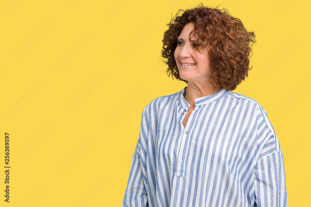 Beautiful middle ager senior woman wearing navy shirt over isolated background looking away to side with smile on face, natural expression. Laughing confident. Beautiful middle ager senior woman wearing navy shirt over isolated background looking away to side with smile on face, natural expression. Laughing confident.