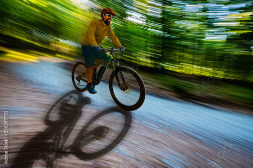 Mountain biker riding on bike in spring mountains forest landscape. Man cycling MTB enduro flow trail track. Outdoor sport activity.