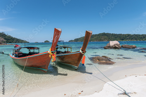 Wooden long-tail boats on crystal tropical sea © Mumemories