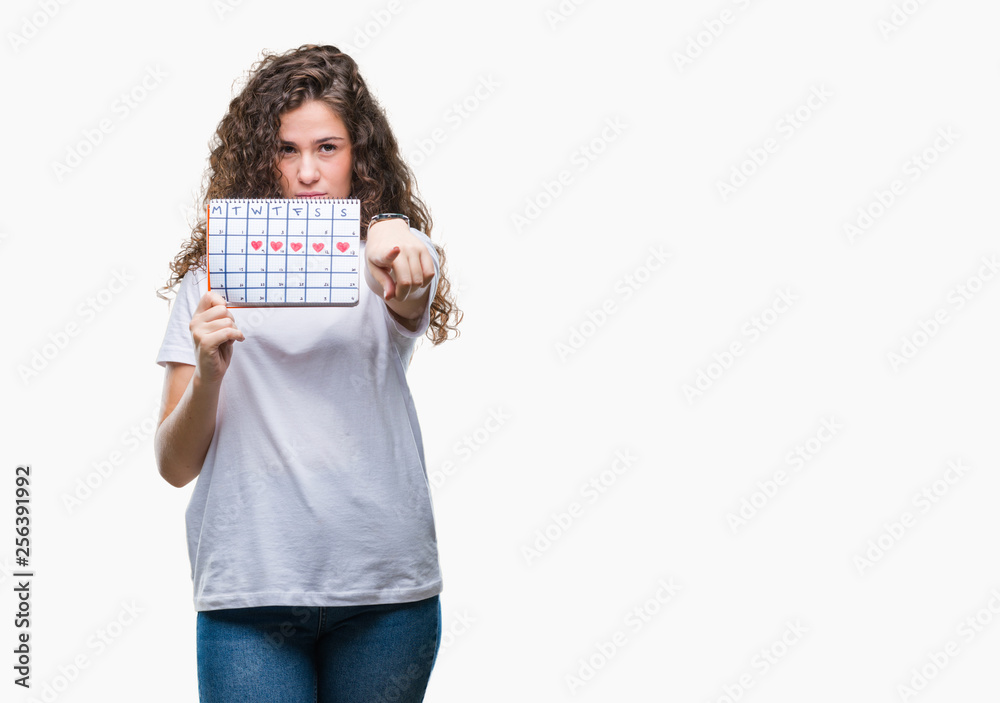 Young brunette girl holding menstruation calendar over isolated background pointing with finger to the camera and to you, hand sign, positive and confident gesture from the front Young brunette girl holding menstruation calendar over isolated background pointing with finger to the camera and to you, hand sign, positive and confident gesture from the front