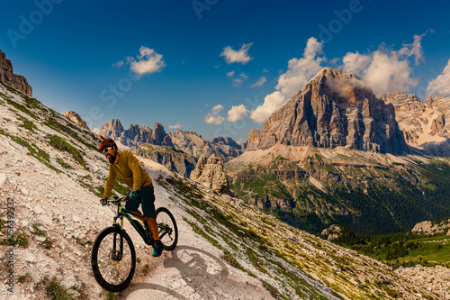 Cycling man riding on bike in Dolomites mountains landscape. Couple cycling MTB enduro trail track. Outdoor sport activity.