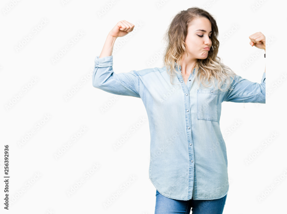 Beautiful young blonde woman over isolated background showing arms muscles smiling proud. Fitness concept. Beautiful young blonde woman over isolated background showing arms muscles smiling proud. Fitness concept.