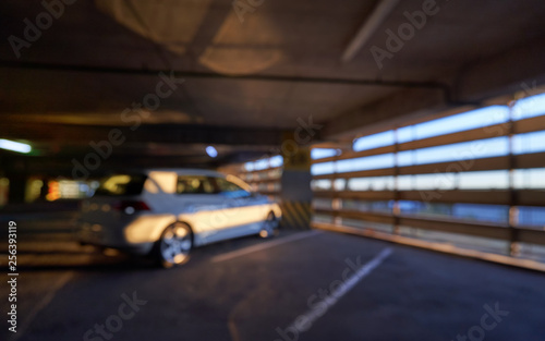 Defocused image and blurred background, car and sun rays on a special parking in the mall.