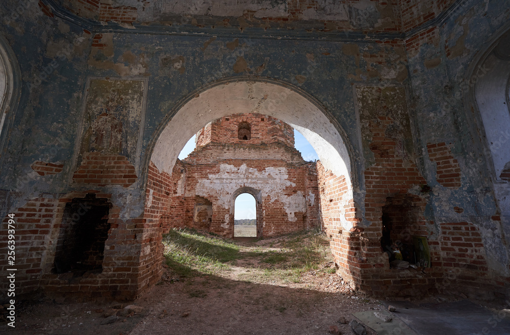 Inside an old abandoned church, shabby brick walls and an arch