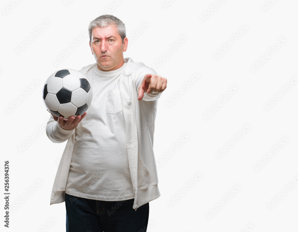 Handsome senior man holding soccer football ball over isolated background pointing with finger to the camera and to you, hand sign, positive and confident gesture from the front Handsome senior man holding soccer football ball over isolated background pointing with finger to the camera and to you, hand sign, positive and confident gesture from the front