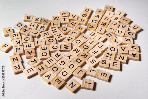 Alphabet letters on wooden scrabble pieces scattered photo