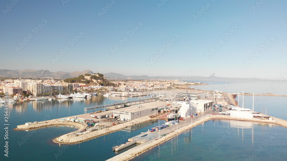 Aerial view of Denia port. The city and the Denia castle in the background.