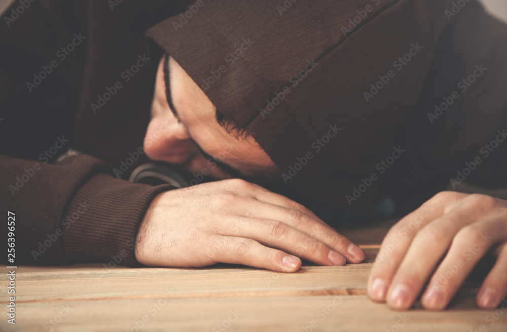 Hooded man sleeping in the desk. Hooded man sleeping in the desk.