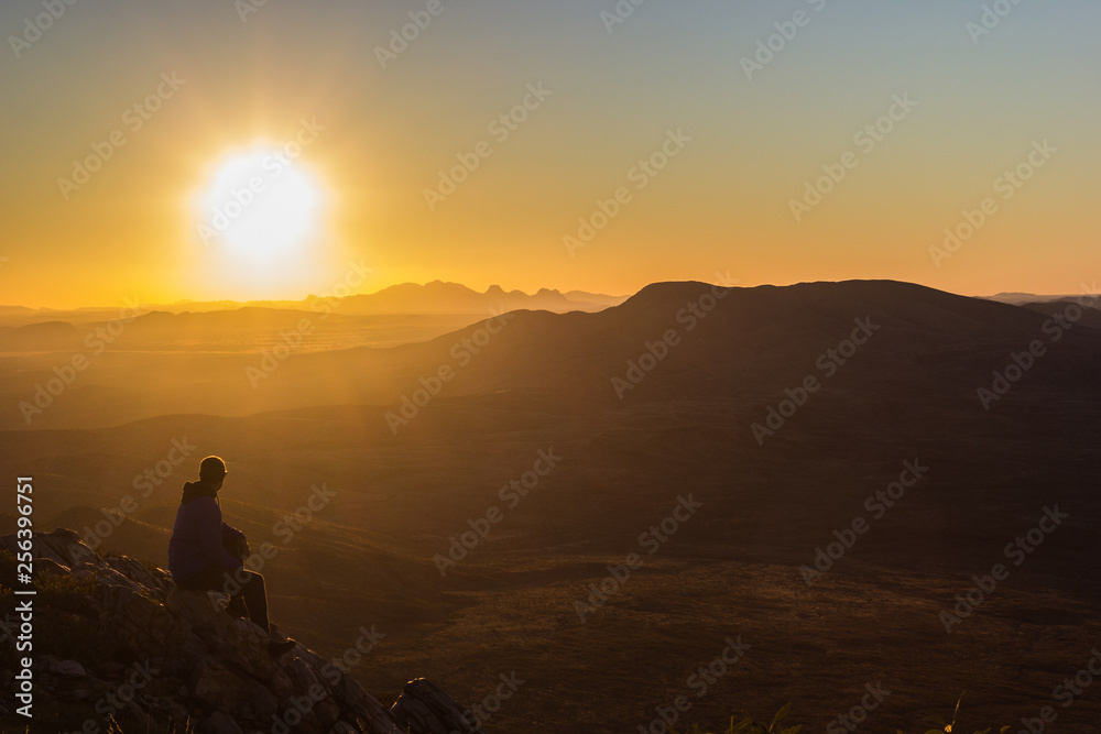 man enjoying sunset after a hike to the top of Mount Sonder just outside Alice Springs, West MacDonnel National Park, Australia
