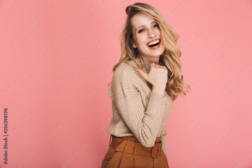 Portrait of beautiful blond woman 30s in stylish outfit smiling and pointing finger at copyspace Portrait of beautiful blond woman 30s in stylish outfit smiling and pointing finger at copyspace