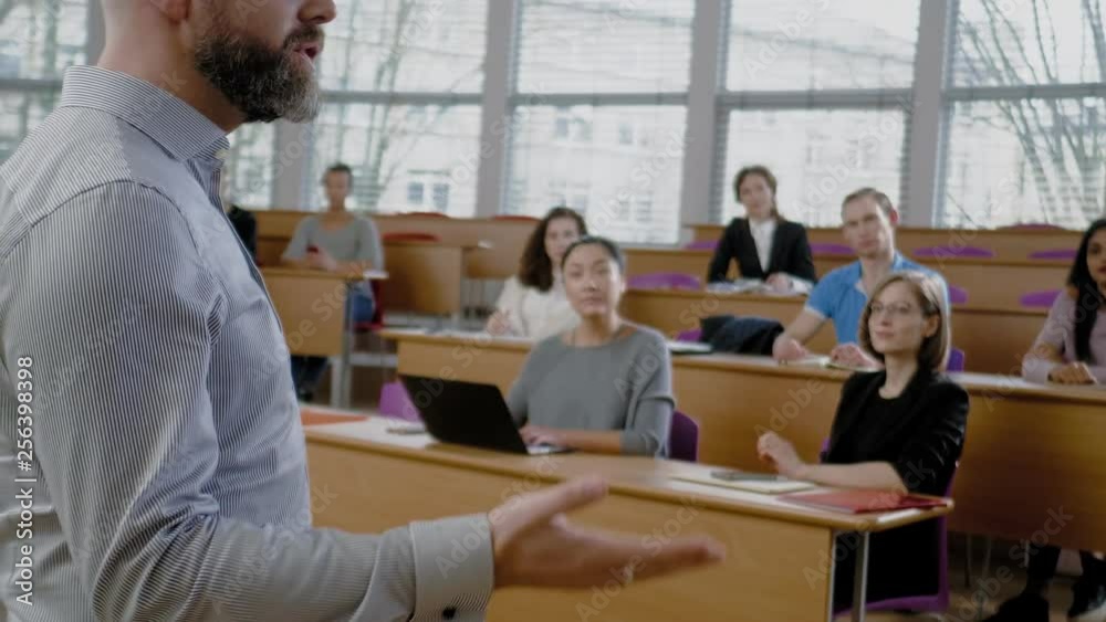 Lecturer and multinational group of students in an auditorium Lecturer and multinational group of students in an auditorium