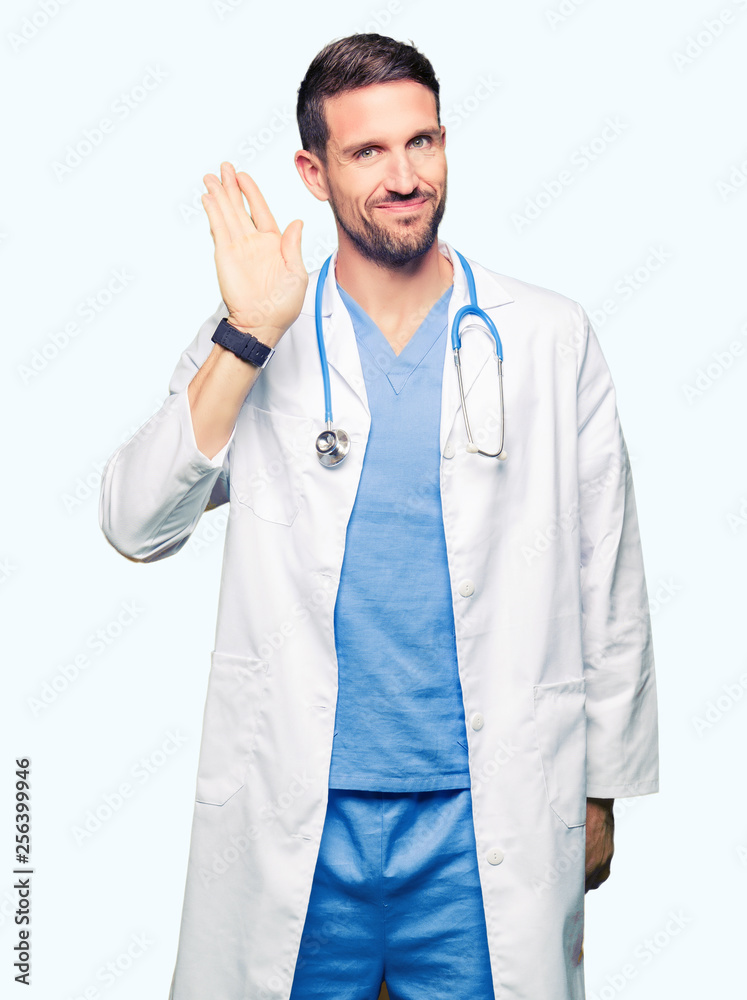 Handsome doctor man wearing medical uniform over isolated background Waiving saying hello happy and smiling, friendly welcome gesture Handsome doctor man wearing medical uniform over isolated background Waiving saying hello happy and smiling, friendly welcome gesture