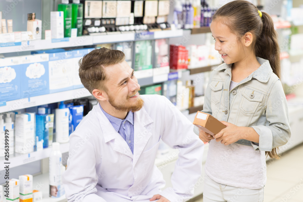 Pharmacist helping little girl at the drugstore