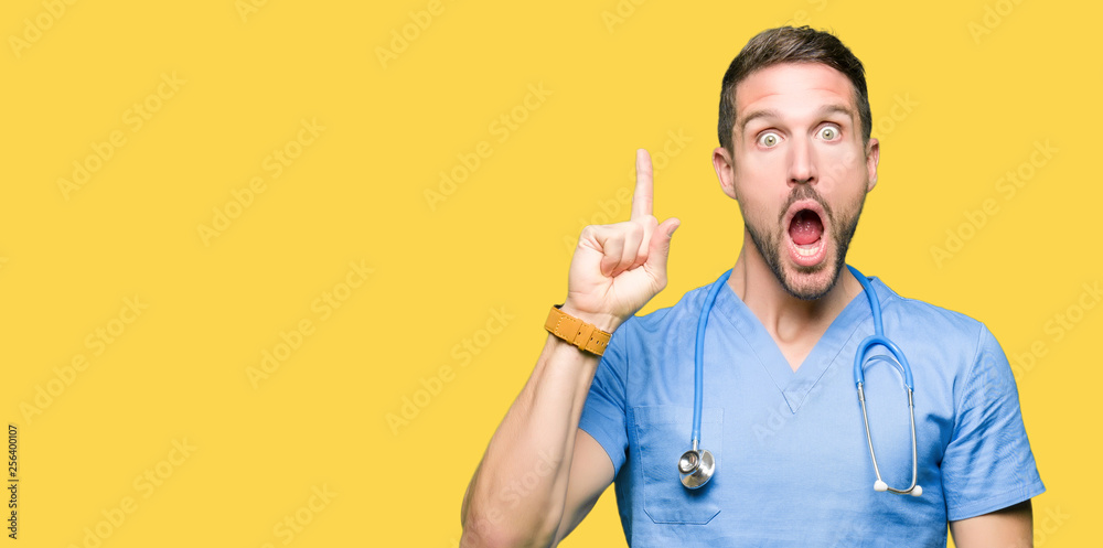 Handsome doctor man wearing medical uniform over isolated background pointing finger up with successful idea. Exited and happy. Number one. Handsome doctor man wearing medical uniform over isolated background pointing finger up with successful idea. Exited and happy. Number one.
