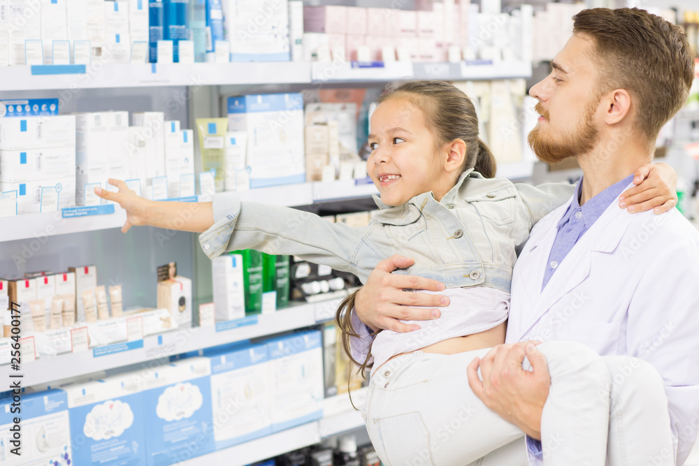 Fototapeta premium Pharmacist helping little girl at the drugstore