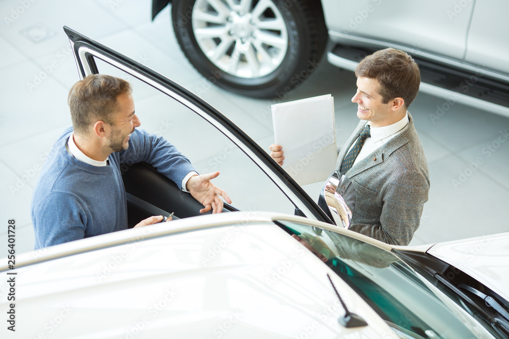 Male customer and car salesman at the dealership Male customer and car salesman at the dealership