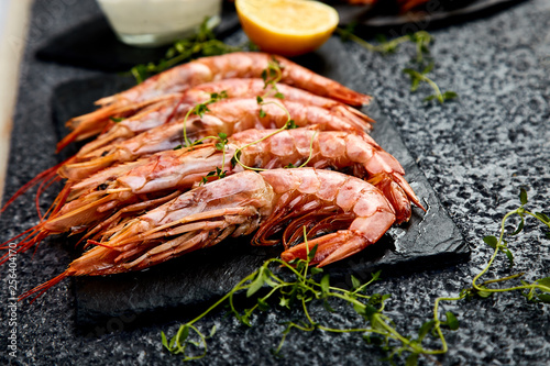 Grilled big tiger shrimps prawns on black slate plate