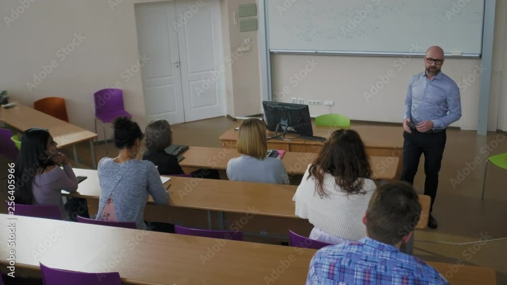 Lecturer and multinational group of students in an auditorium Lecturer and multinational group of students in an auditorium