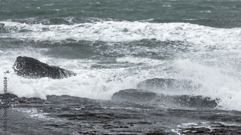 Splash of huge waves on a rocky shore