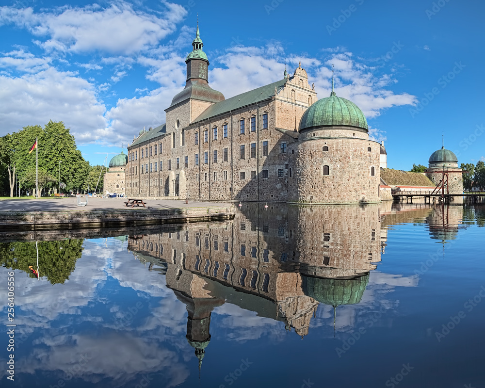 Vadstena Castle in the city of Vadstena, Sweden. The main castle building reflects in the water of moat. Construction of the castle was started in 1545. The castle was completed in 1620.
