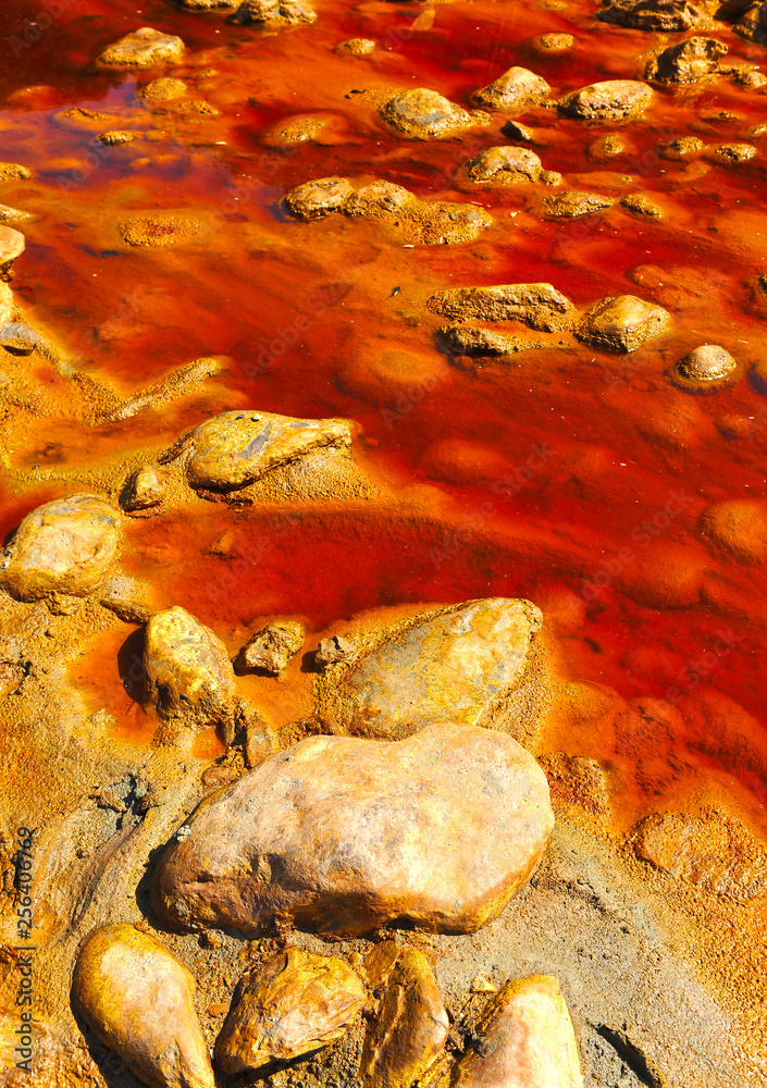 Contamined reddish background. Acidic waters of the Tinto River (Río Tinto), province of Huelva, Andalusia, Spain Contamined reddish background. Acidic waters of the Tinto River (Río Tinto), province of Huelva, Andalusia, Spain
