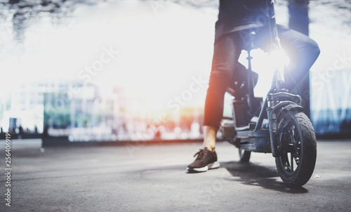Electric urban transportation.Young man ready to ride his electric scooter bike in the center of a city