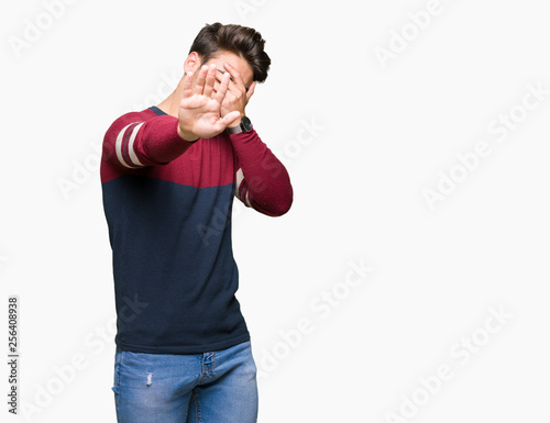 Young handsome man over isolated background covering eyes with hands and doing stop gesture with sad and fear expression. Embarrassed and negative concept.