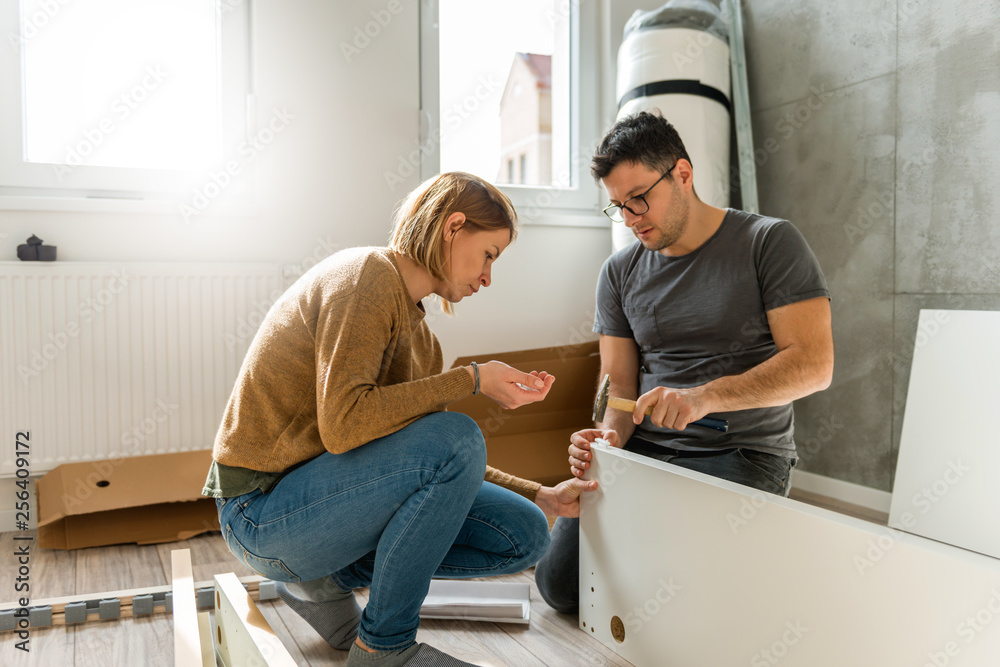 Couple assembling furniture in their new house Couple assembling furniture in their new house
