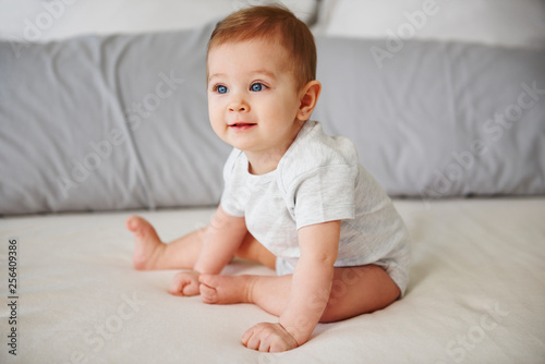 Obraz na płótnie Adorable baby girl sitting on bed