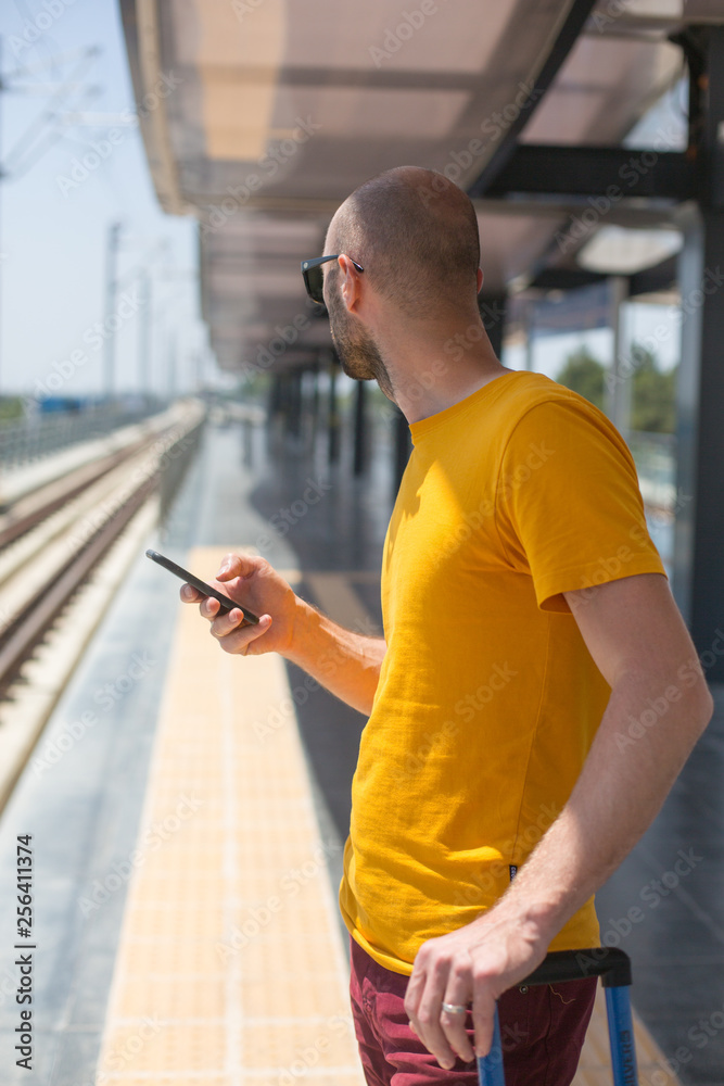 Antalya, Turkey - 28 May, 2018 The guy in the yellow shirt stands at the bus stop at the airport and is waiting for the subway. Antalya, Turkey - 28 May, 2018 The guy in the yellow shirt stands at the bus stop at the airport and is waiting for the subway.