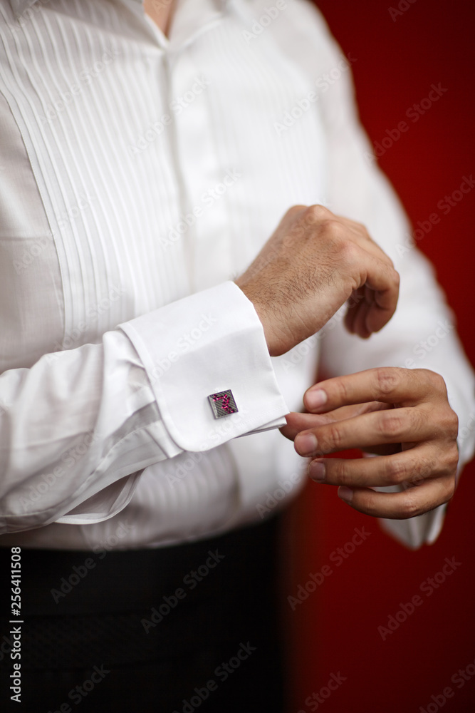 groom buttoning shirt