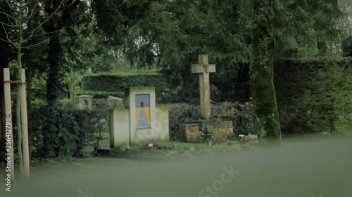 Cross and Tombstone in Green Graveyard