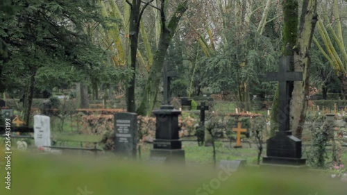 Cross and Tombstone in Green Graveyard
