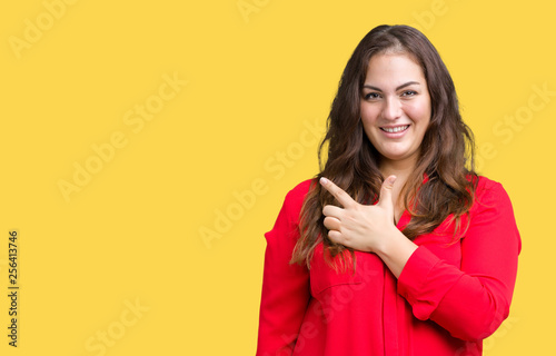 Beautiful plus size young business woman over isolated background cheerful with a smile of face pointing with hand and finger up to the side with happy and natural expression on face © Krakenimages.com