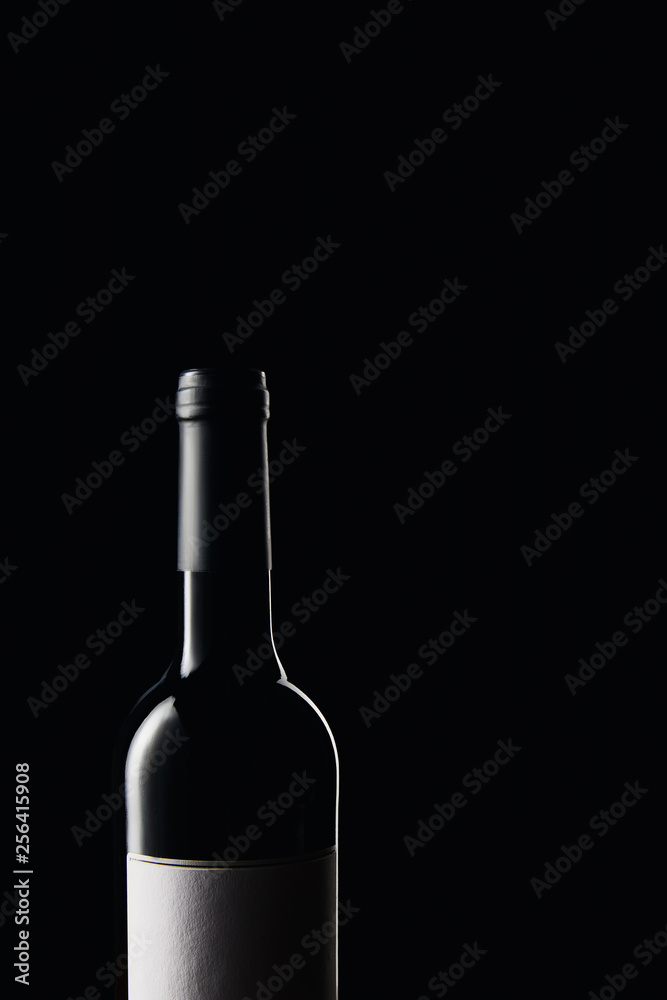 Glass wine bottle with blank label isolated on black Glass wine bottle with blank label isolated on black