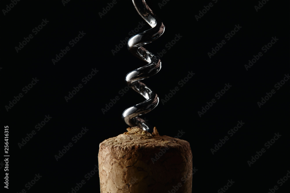 Close up view of wooden cork and steel corkscrew isolated on black Close up view of wooden cork and steel corkscrew isolated on black