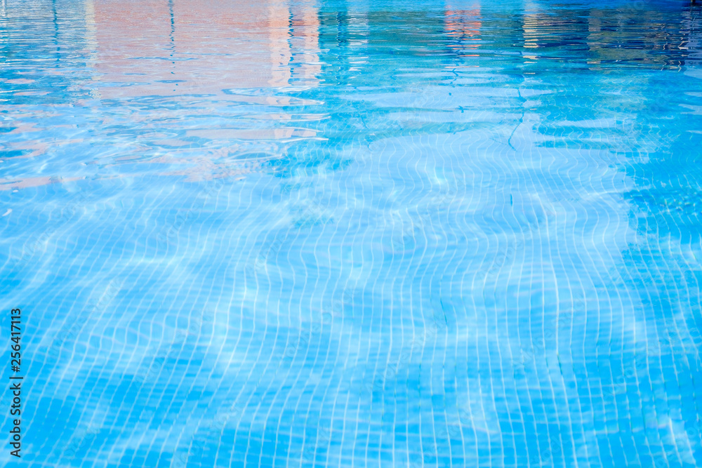 Closeup view of the swimming pool blue water surface copy space during a sunny summer day