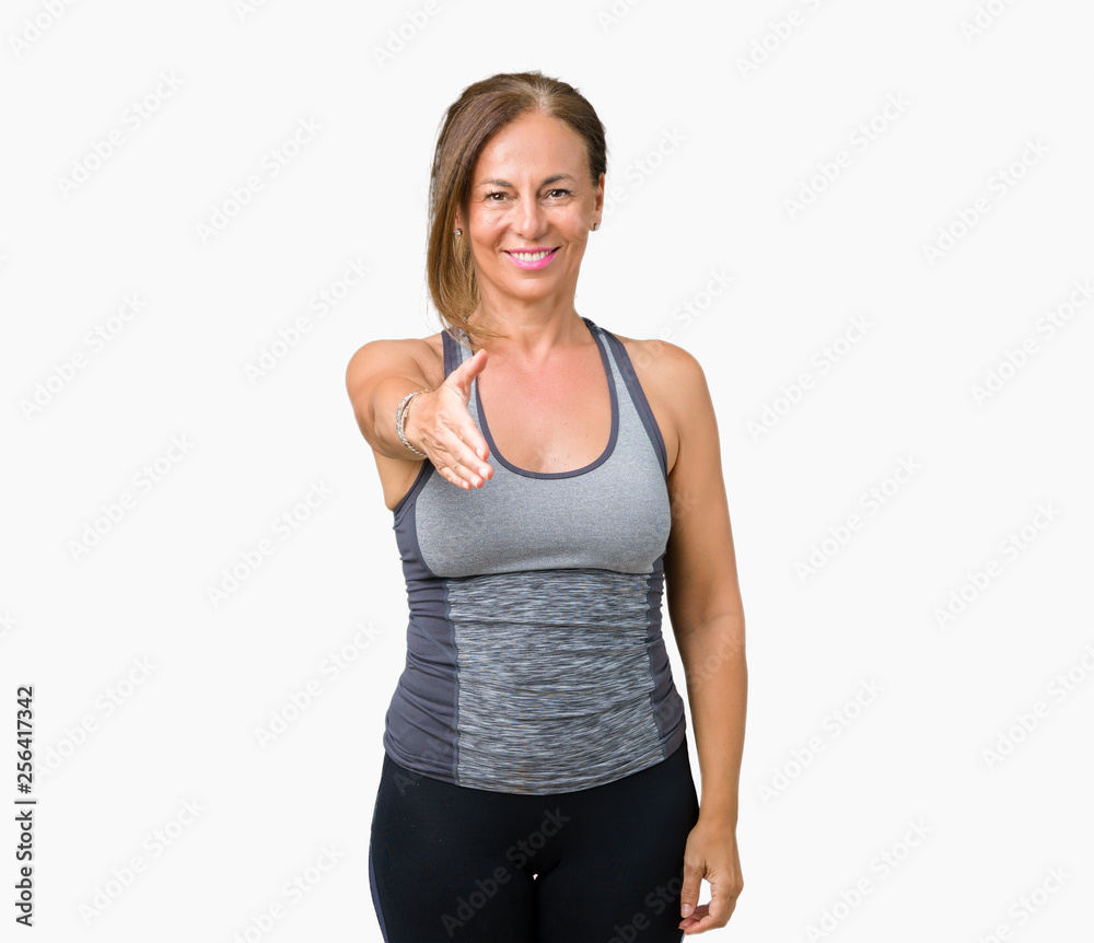 Beautiful middle age woman wearing sport clothes over isolated background smiling friendly offering handshake as greeting and welcoming. Successful business. Beautiful middle age woman wearing sport clothes over isolated background smiling friendly offering handshake as greeting and welcoming. Successful business.