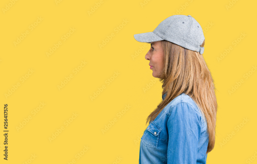 Woman in Yellow Shirt Wearing Black Leather Cap Posing In Front of Green  Gate · Free Stock Photo
