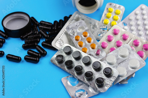 various packs of pills on a blue background.