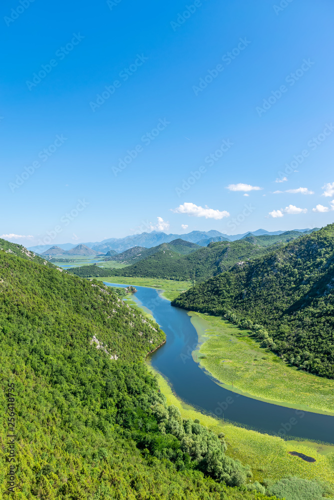 The picturesque meandering river flows among green mountains.